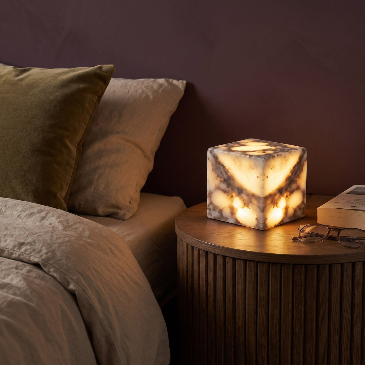 Brasa en una mesilla de roble en un dormitorio de paredes ciruela