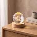 Luma Saturno, esfera de cristal con Saturno grabado sobre base de madera