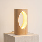 Nido, lámpara de madera maciza con un hueco ovalado iluminado