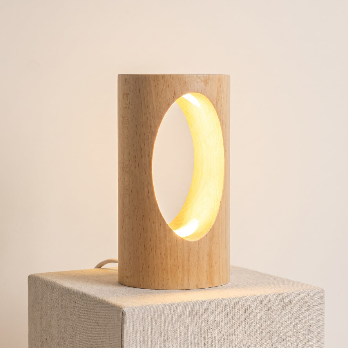 Nido, lámpara de madera maciza con un hueco ovalado iluminado