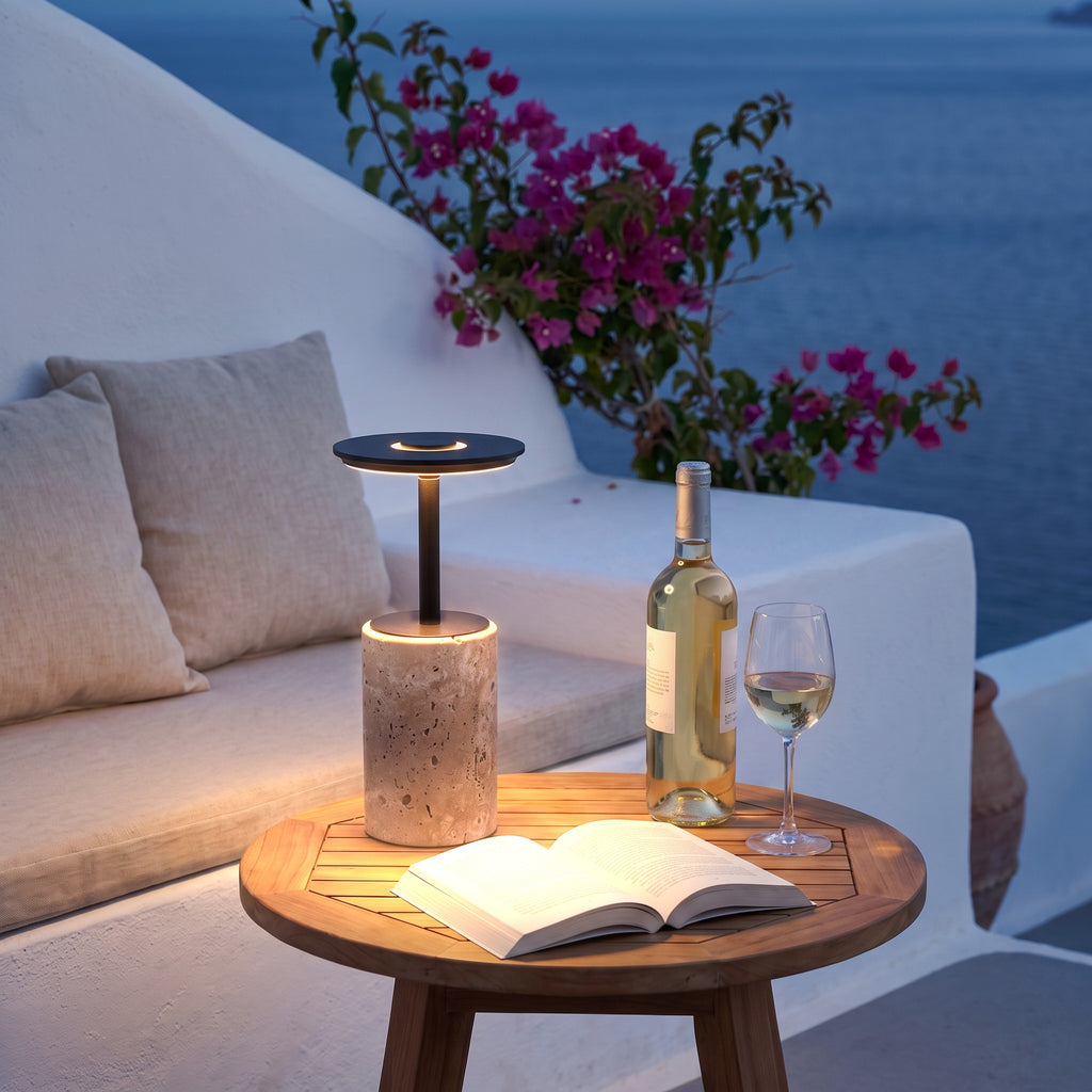 Petra encendida en una mesa de teca de una terraza mediterránea al anochecer